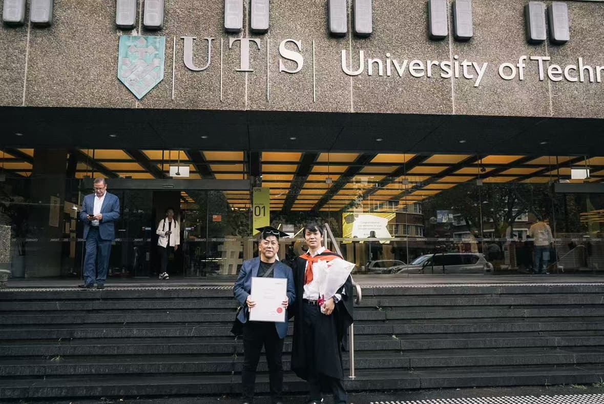 UTS（シドニー工科大学）前で卒業生と共に修了証書を手にする日影恒次代表