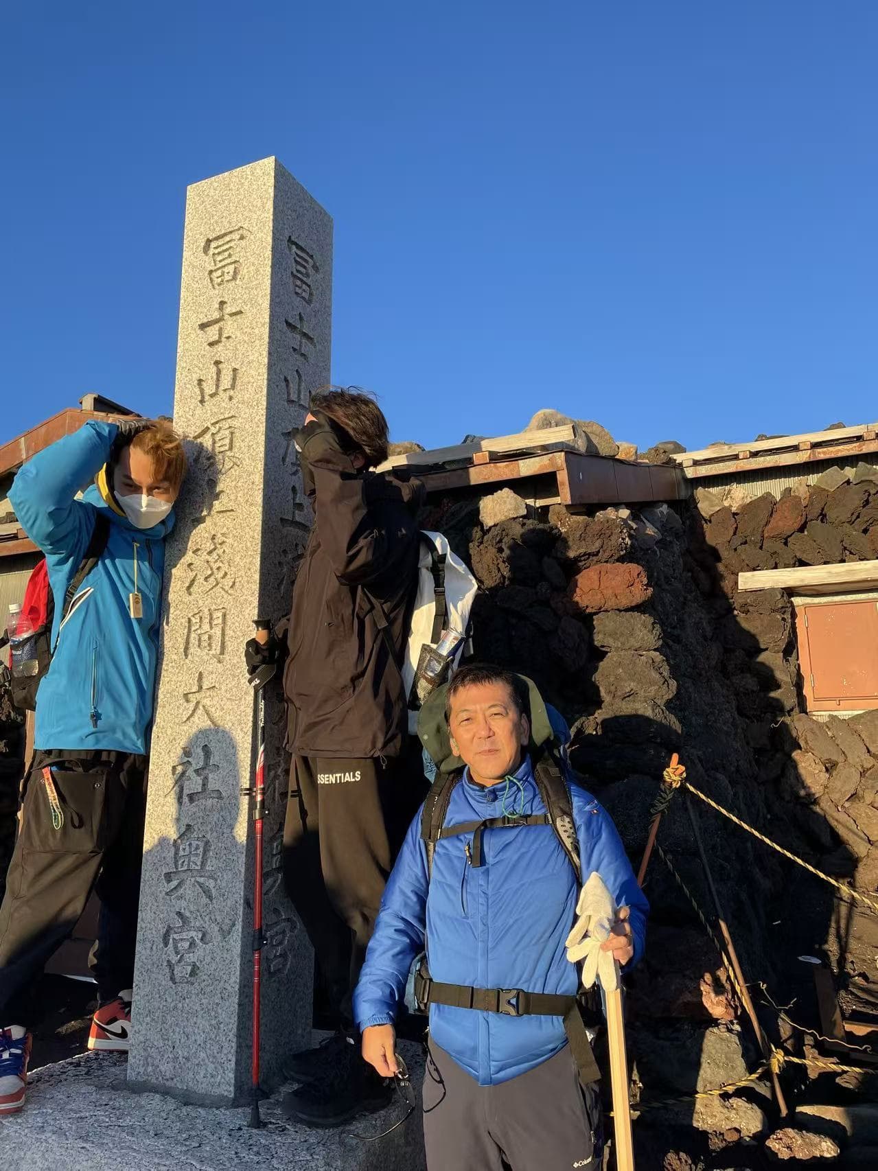 富士山頂の浅間大社奥宮にて登山装備姿の日影恒次代表