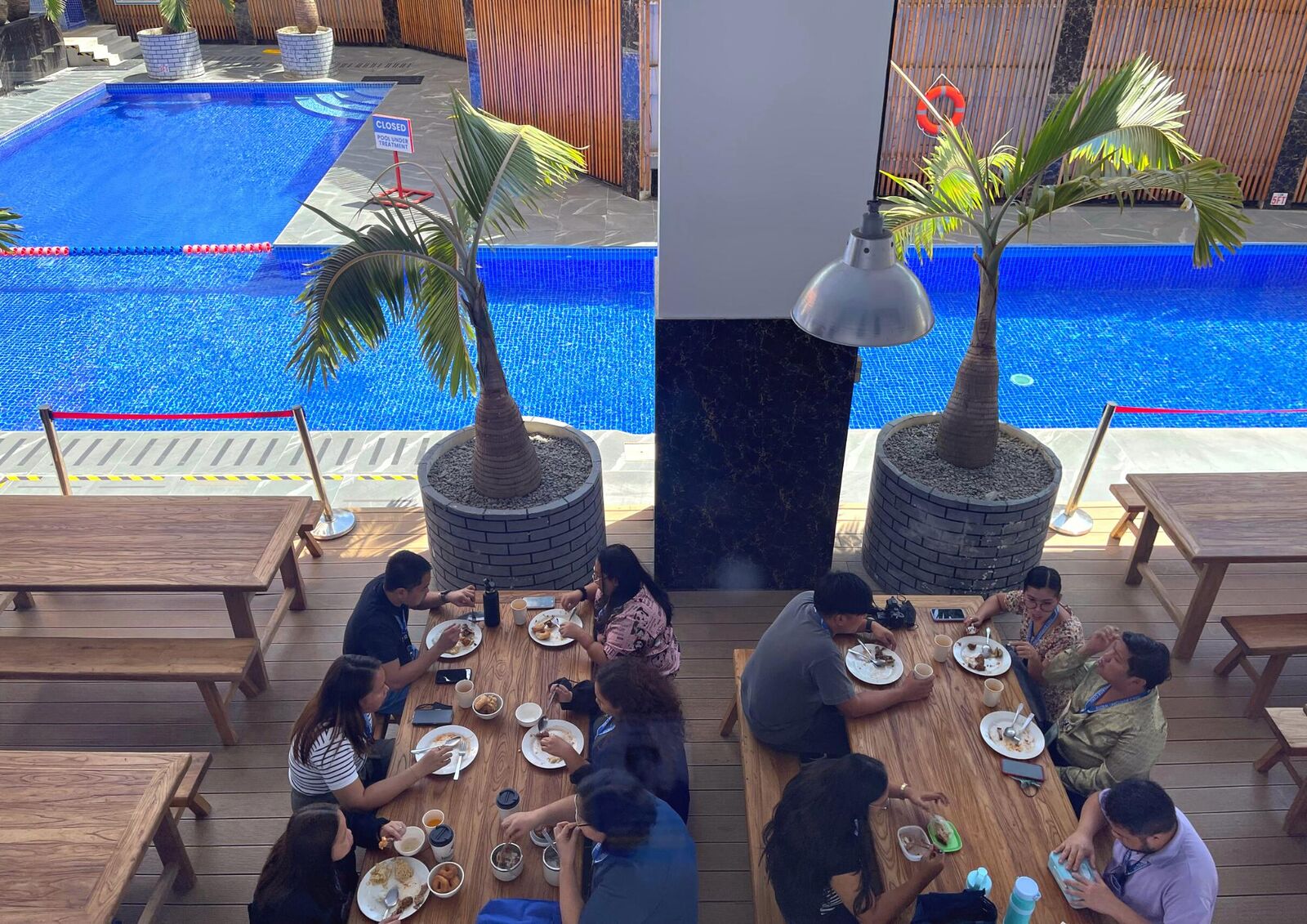 在泳池边用餐的学生们